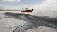 From a hillside, Kamal Saadat looked forlornly at hundreds of potential customers, knowing he could not take them for trips in his boat to enjoy a spring weekend on picturesque Oroumieh Lake, th...